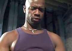 Two sexy dark-skinned hunks with amazing bodies get it on in a dimly lit room