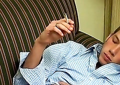 Gay guy smokes while stripping naked and stroking his cock