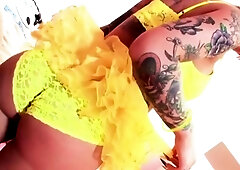 Tattooed brown-haired in a yellow tutu enjoys solo