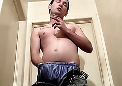 Tattooed twink strips while smoking and strokes his hard cock