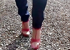 Seductive shemale loves walking outdoors in her red high heels