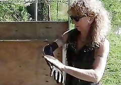 Leather wearing mistress prepares her fists for slaves ass BDSM