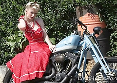 Blonde pornstar Casey Deluxe strips down in a red polka-dot dress beside a vintage motorcycle