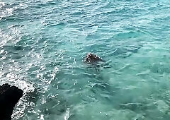 A exposed Monika Fox swims in the sea and walks along the coast.