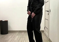 She-Male in a leather jumpsuit romper and high high-heeled shoes SADISM & MASOCHISM