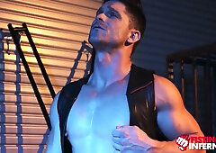 Muscular leatherman dominates submissive stud in industrial BDSM session
