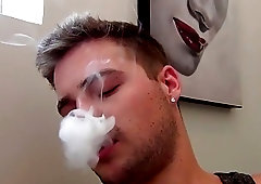 Stud takes his clothes off while smoking and masturbates solo