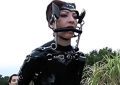 Latex freaks playing out kinky lesbian BDSM fantasy outdoors