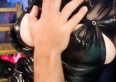 The slutty redhead is a breasty woman having sex in latex