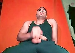 Enjoying a giant knob against a carrot-colored backdrop - GuitarJob's solo guitar jerk-off