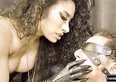 Unshaved-haired woman in leather gloves grasps and controls a blindfolded stud...